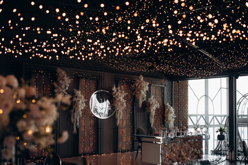 candles and lights of garlands at night on the festive table