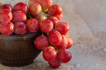 Bunch of grapes. Ripe large grape berries in a ceramic bowl on an abstract background. Vine.