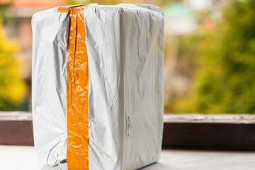 Real postal package, white box with orange stripe with ordered item