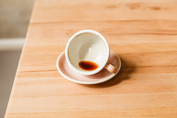 An empty cup with a drop of Americano on the table. Drunk black coffee. Stylish banner with space for tex