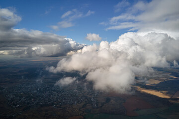 Fototapeta na wymiar Aerial view from airplane window at high altitude of earth covered with white puffy cumulus clouds