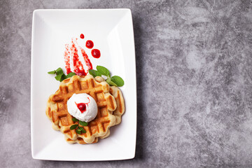 Homemade freshly baked belgian waffles with mascarpone, mint leaves and strawberry sauce - 501632422