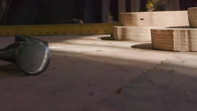 A construction worker throws a hammer onto a table with building materials