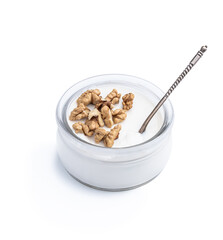 Fresh natural homemade organic yogurt with walnuts in a glass jar isolated on white