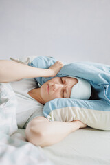 woman lies in bed and yawns or sleeps with a sleeping mask on her face. a European woman with sleep problems and insomnia, waking up and falling asleep in a cozy house. sleep disorders or depression
