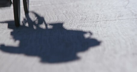 Shadow of a man cycling on an urban street
