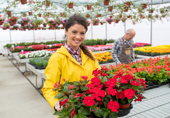 Portrait of woman with flowers in plant nursery center