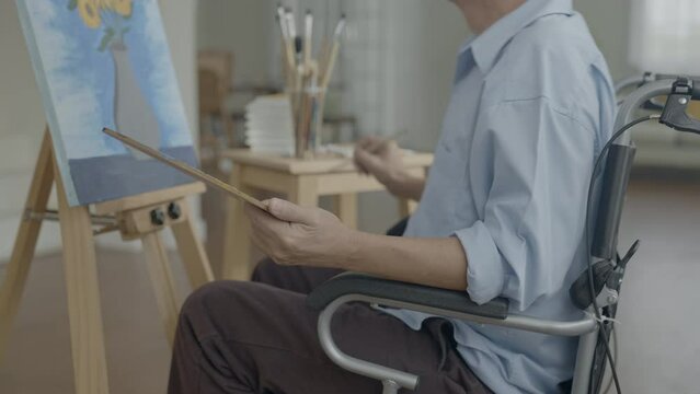 Artist concept of 4k Resolution. Asian man painting in the living room. Artist is creating work. Leisure activities and hobbies.