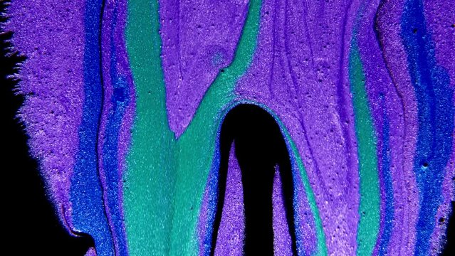 Abstract paint mixing neon blue green and violet purple colors ink. Liquid colorful amazing organic background.