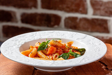 Penne in tomato sauce with basil on top