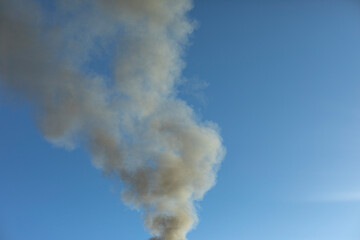 Fototapeta na wymiar Smoke and sky. Black smoke billows in air.