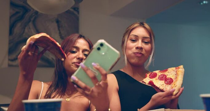 Two college girls take a selfie with their pizza in their kitchen