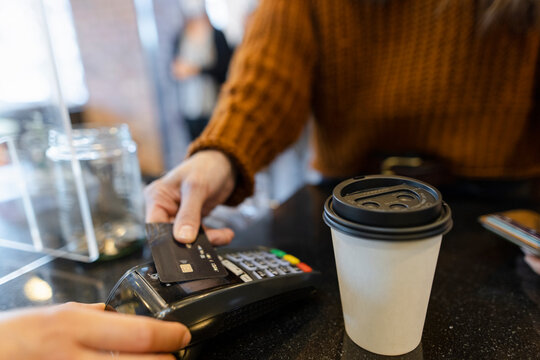 Close up woman with credit card paying for coffee