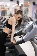 Fototapeta premium Adult woman running on treadmill