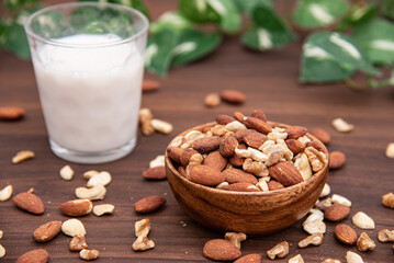 木の器に盛られたミックスナッツとアーモンドミルク