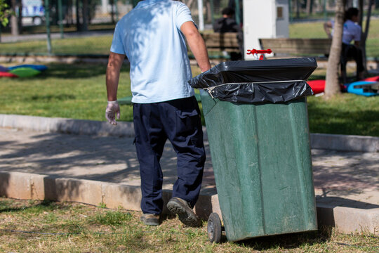 Man carrying garbage with garbage container