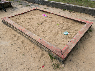 Old sandbox with wooden edging and toys.