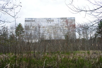 An old abandoned drive-in movie screen being overtaken by nature turning the whole area back into a swamp