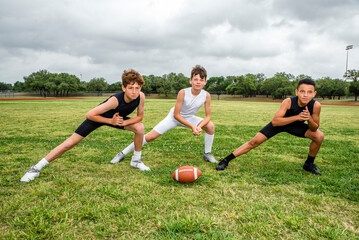 Youth football players stretching before a game