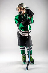 Male youth hockey player in full gear standing on the ice 