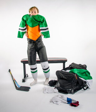 Male youth hockey player getting dressed for a game