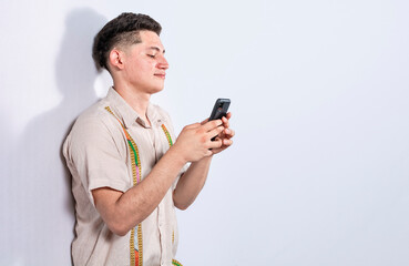 Handsome guy happy with his cell phone on isolated backgrounds, young latin man happy with his cell phone isolated, man on white background texting with his cell phone