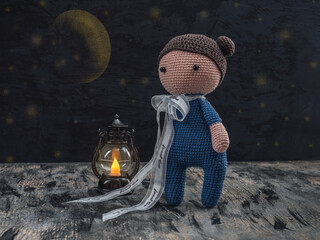 Doll in a blue suit with a burning lantern, amigurumi crochet doll with a blue bow
