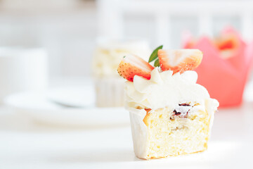 Sliced cupcake on white table against blurred background.