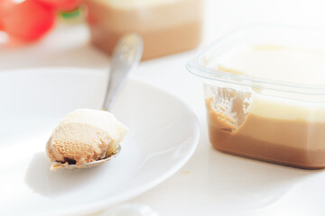 On white plate lies spoon with three types of chocolate.