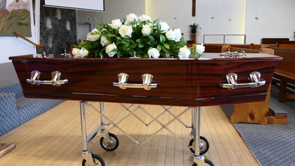 closeup shot of a funeral casket or coffin in a hearse or chapel or burial at cemetery
