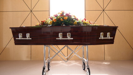 closeup shot of a funeral casket or coffin in a hearse or chapel or burial at cemetery
