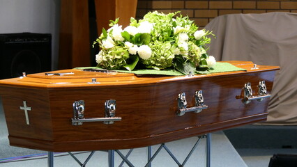 closeup shot of a funeral casket or coffin in a hearse or chapel or burial at cemetery
