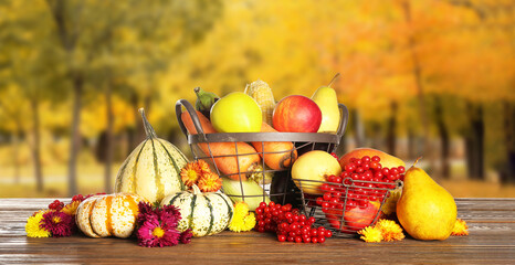 Baskets with gathered harvest on table in autumn garden