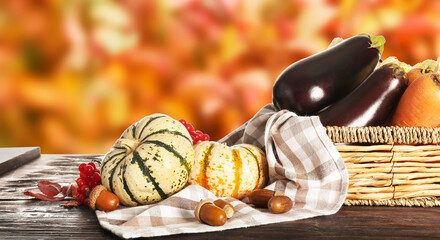 Basket with gathered harvest on table in autumn garden