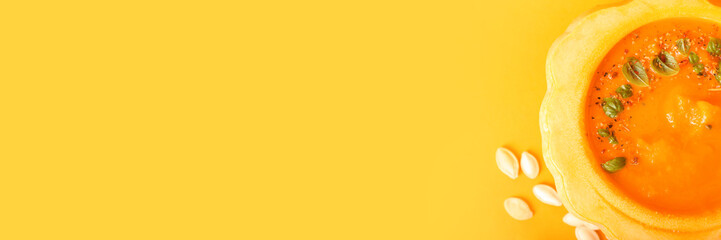 Delicious pumpkin cream soup on orange background with space for text