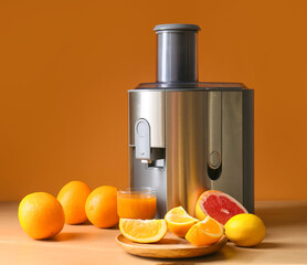 New modern juicer and glass of fresh juice with fruits on table