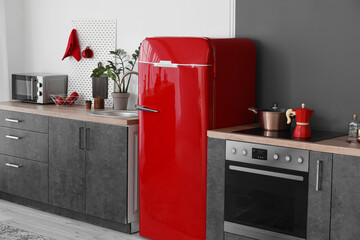 Red retro fridge and modern counters in kitchen