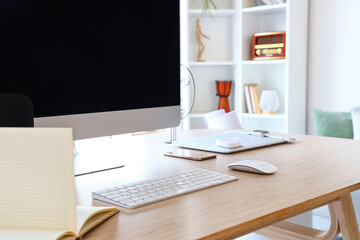 Modern computer and mobile phone on table, closeup