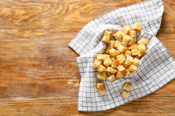 Napkin with tasty croutons on wooden background