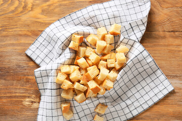 Napkin with tasty croutons on wooden background