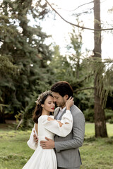 Young beautiful wedding couple hugging in the forest. Lovely couple, bride and groom posing, lifestyle
