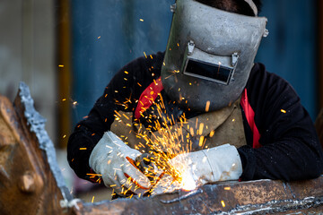 Welder in Iron mask helmet welds steel welding, Industrial worker at the factory welding steel...