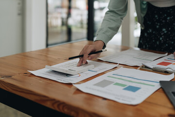 Close up accountant woman using calculator for do math finance on wooden desk in office and business working background, tax, accounting, statistics and analytic research concept