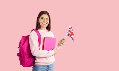 Happy university student with flag of UK. Beautiful young woman with backpack standing on pink...