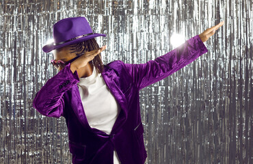 African American woman in disco suit isolated on glitter background dab dance. Overjoyed black...