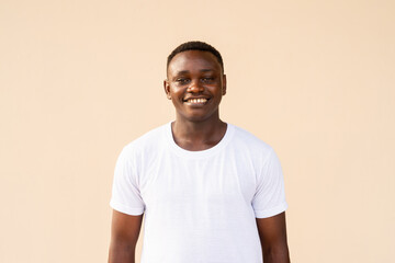 Portrait of handsome African man wearing white t-shirt while smiling