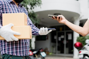 Asian customer young woman using mobile smartphone with QR code payment to receive parcel post box from delivery man, Hands of female scanning at door front house, Online shopping service concepts