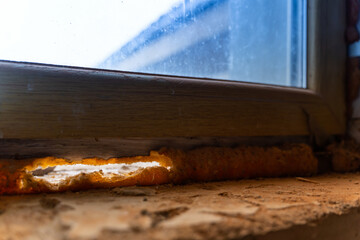 Through hole in the mounting foam under the window. Old unusable mounting foam. Draft through the window. Heat loss in the house