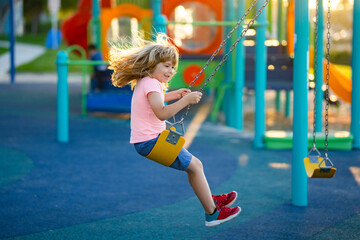 Colorful playground on yard in the park. Child playing on the playground in kindergarten. Joyful kid on the playground.