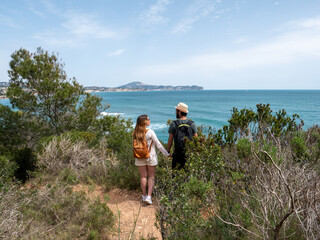 young couple hiking on the beach with the sea on the background